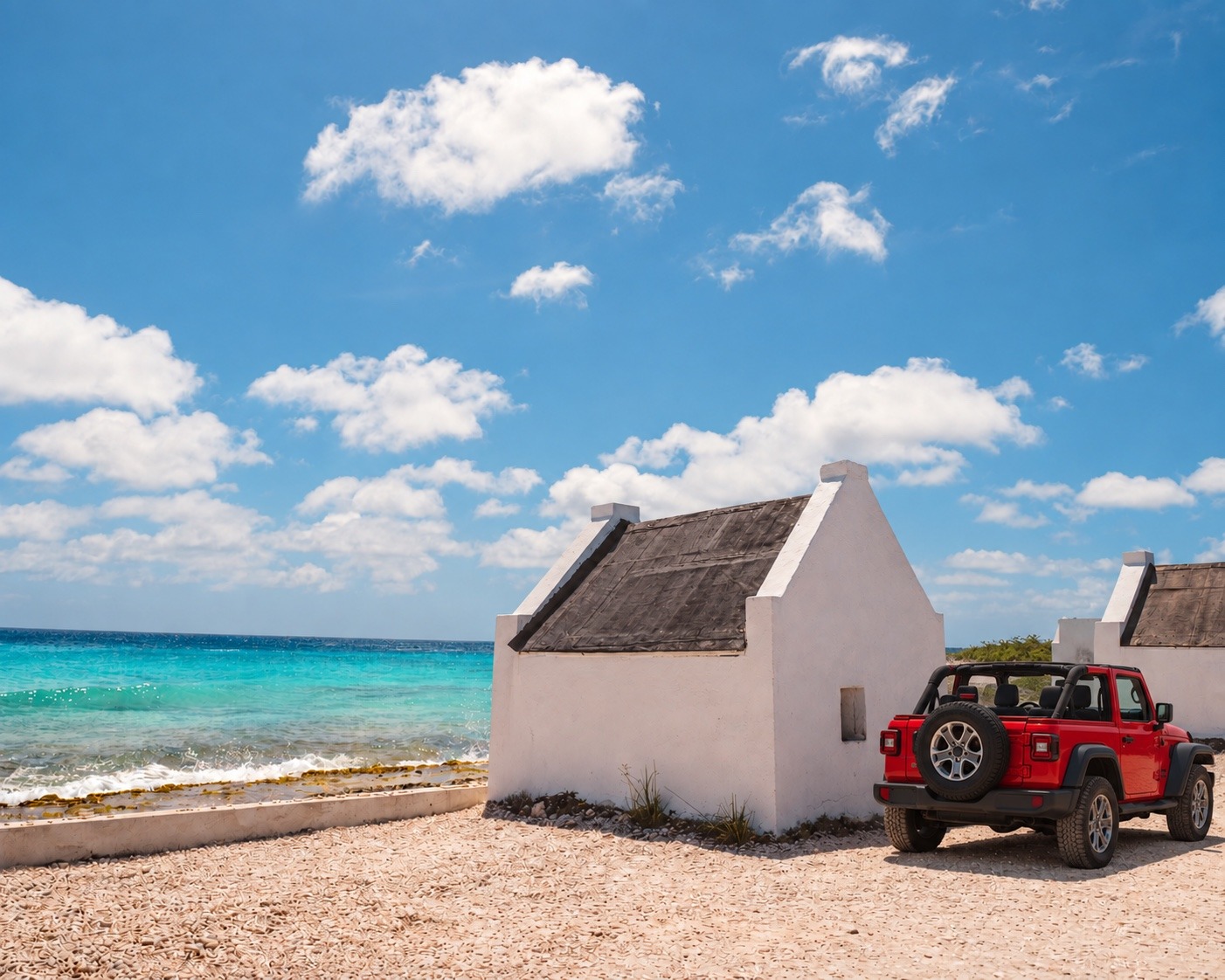 Red Jeep beside the white slave huts on Bonaire